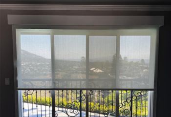 Living room in San Jose featuring sheer roller shades partially drawn over patio doors, allowing sunlight while maintaining privacy.